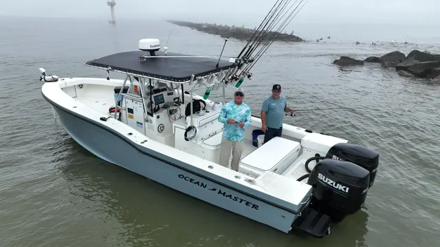 The 31 ft Ocean Master Half Time at the Galveston jetty in morning fog, two anglers on deck