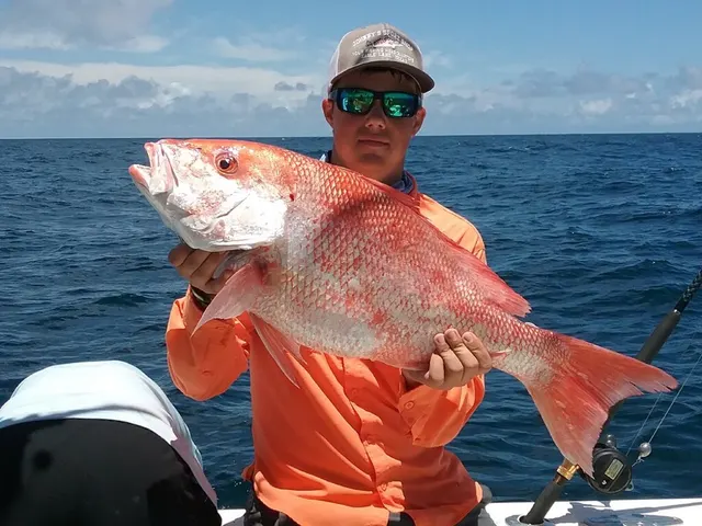Young angler holding a red snapper from an offshore reef trip